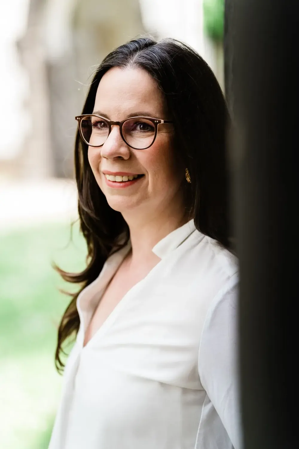 Dr. Michaela Fischbach im hellen Hemd, seitlich lächelnd